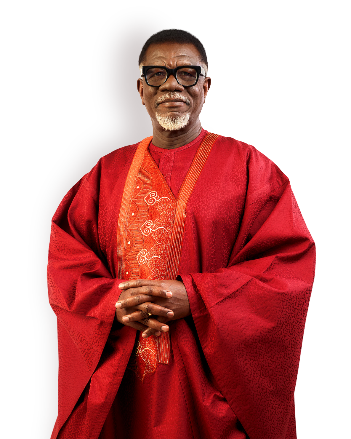 Mensa Otabil in a red ceremonial agbada, hands clasped